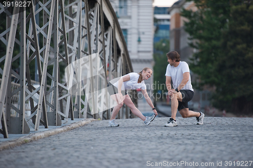 Image of couple warming up and stretching before jogging