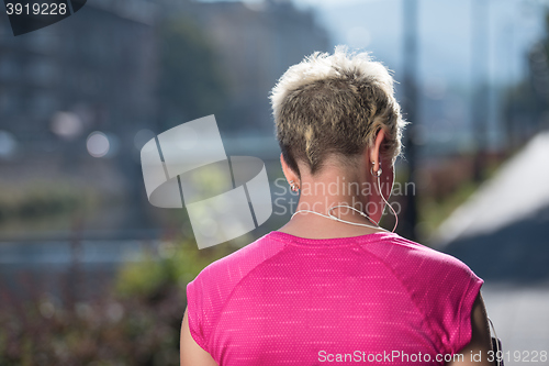 Image of jogging woman setting phone before jogging