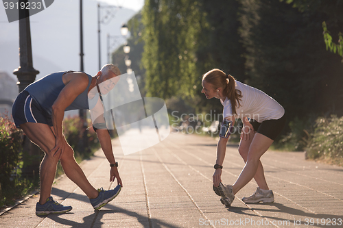 Image of couple warming up and stretching before jogging