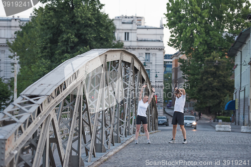 Image of couple warming up and stretching before jogging