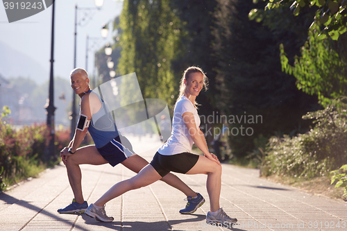 Image of couple warming up and stretching before jogging