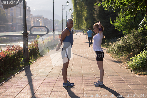 Image of couple warming up and stretching before jogging