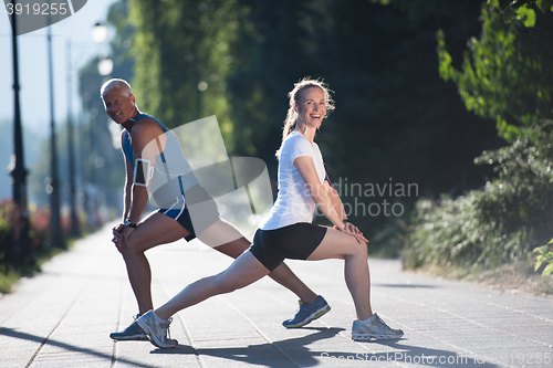 Image of couple warming up and stretching before jogging