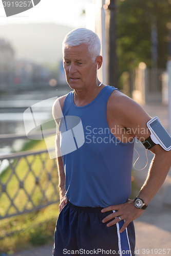 Image of portrait of handsome senior jogging man