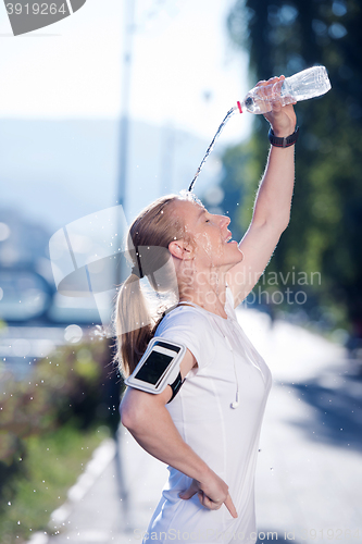 Image of woman drinking  water after  jogging