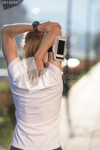 Image of blonde woman  stretching before morning jogging