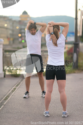 Image of couple warming up before jogging