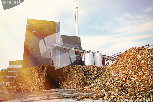 Image of bio power plant with storage of wooden fuel (biomass) against bl