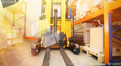 Image of Forklift, shelves and racks with pallets in distribution warehou