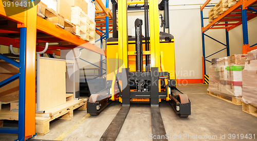 Image of Forklift, shelves and racks with pallets in distribution warehou