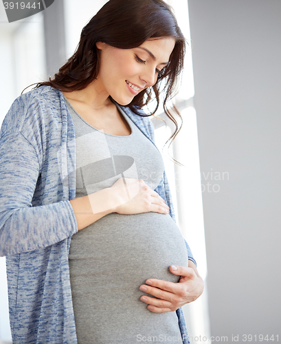 Image of happy pregnant woman with big tummy at home