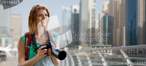 Image of woman with backpack and camera over dubai city