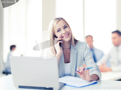 Image of businesswoman with phone in office