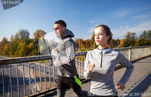 Image of happy couple running outdoors