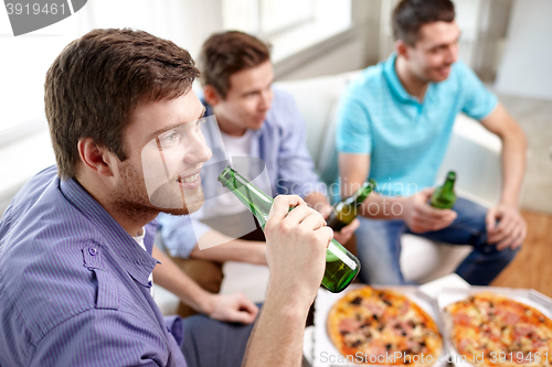 Image of close up of friends with beer and pizza at home