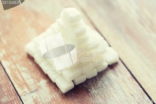Image of close up of white sugar pyramid on wooden table