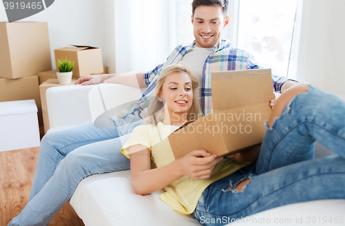 Image of happy couple with big cardboard boxes at new home