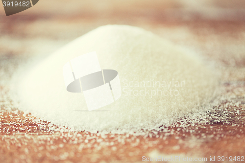 Image of close up of white sugar heap on wooden table