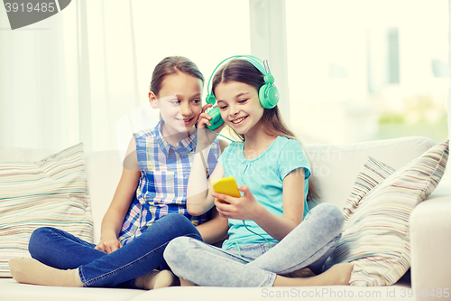 Image of happy girls with smartphone and headphones