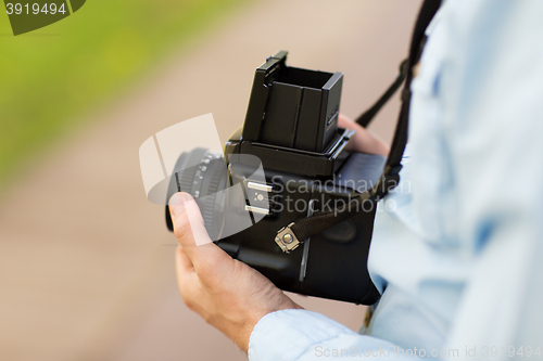 Image of close up of male photographer with digital camera