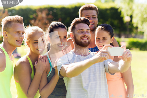 Image of happy friends taking selfie with smartphone