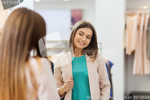 Image of happy woman posing at mirror in clothing store