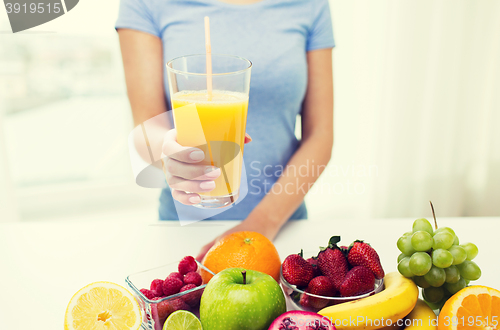 Image of close up of woman holding orange juice with fruits