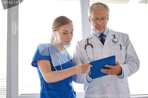 Image of senior doctor and nurse with tablet pc at hospital