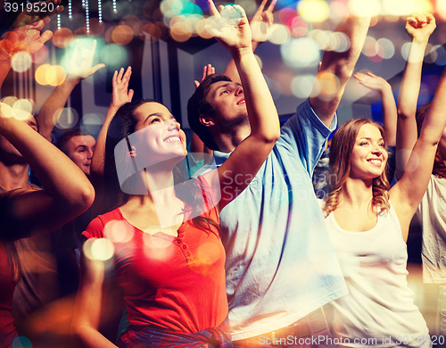 Image of smiling friends at concert in club