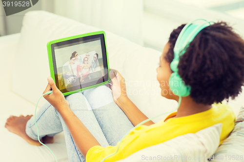 Image of happy african woman with tablet pc and headphones