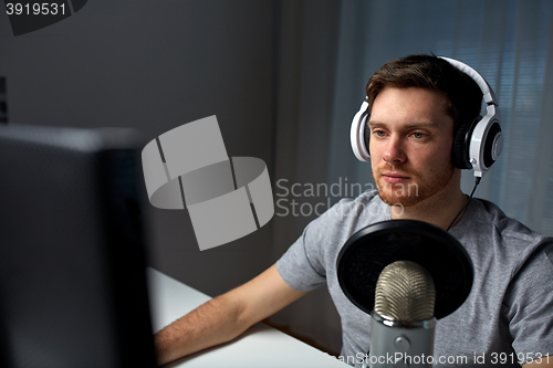 Image of man in headset playing computer video game at home