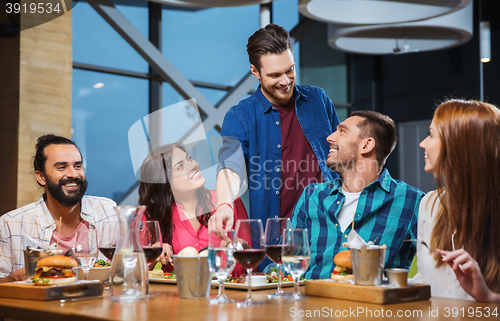 Image of friends dining and drinking wine at restaurant