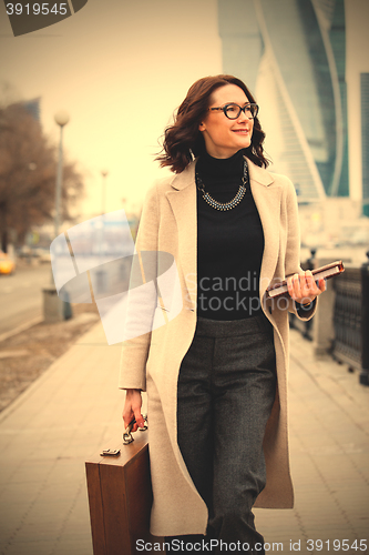 Image of woman in a bright coat with a book in his hands