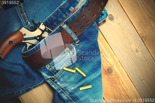 Image of fashion old blue jeans and vintage revolver