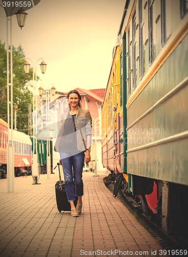 Image of beautiful middle-aged woman with a luggage