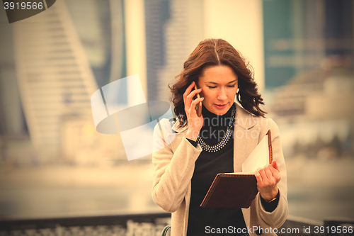 Image of beautiful middle-aged woman using a smartphone