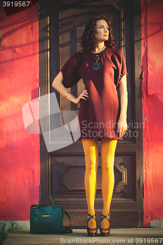 Image of woman in a fashionable burgundy dress and orange pantyhose