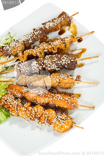 Image of Grilled juicy skewered shashlik on a plate, sesame