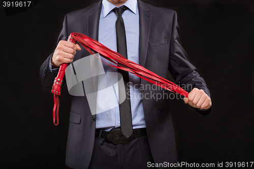 Image of man in business suit with chained hands. handcuffs for sex games