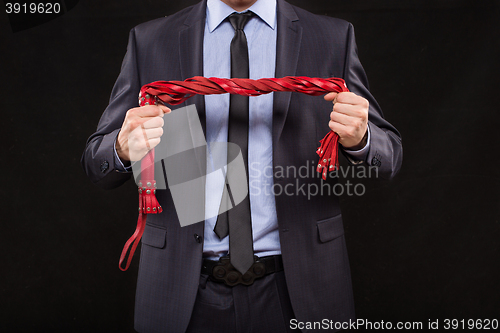 Image of man in business suit with chained hands. handcuffs for sex games