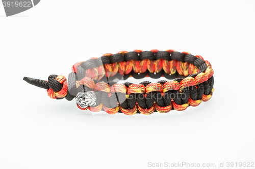 Image of black and orange braided bracelet on white background