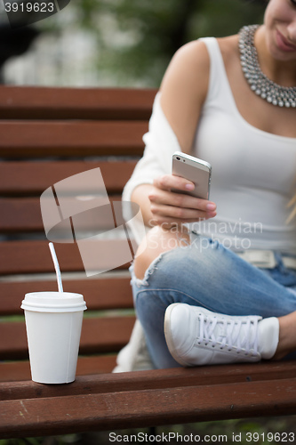 Image of beautiful girl on the street corresponded by phone. 