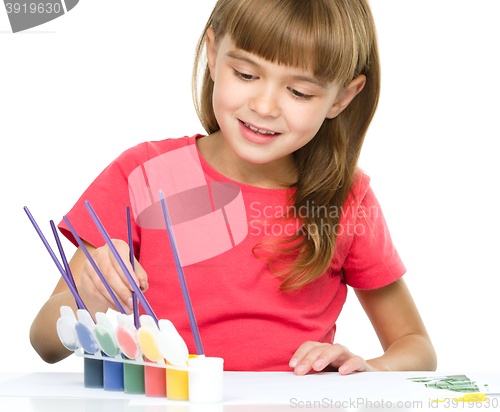 Image of Little girl is painting with gouache