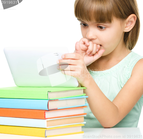 Image of Young girl is using tablet while studying