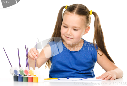 Image of Little girl is painting with gouache