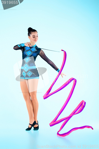 Image of The girl doing gymnastics dance with colored ribbon on a blue background