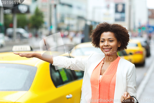 Image of happy african woman catching taxi