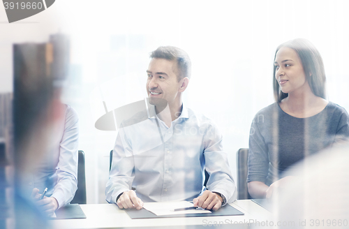 Image of group of smiling businesspeople meeting in office