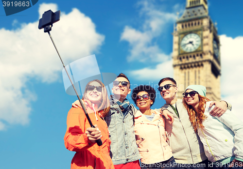 Image of smiling friends taking selfie with smartphone