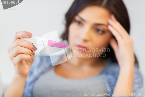 Image of close up of sad woman with home pregnancy test